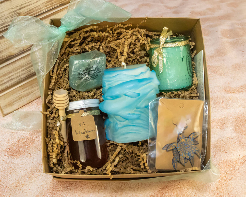 Ocean Longing Gift Box, it comes with a blue glass votive, whale pillar, jar of honey, turtle earrings, and a soap bar.
